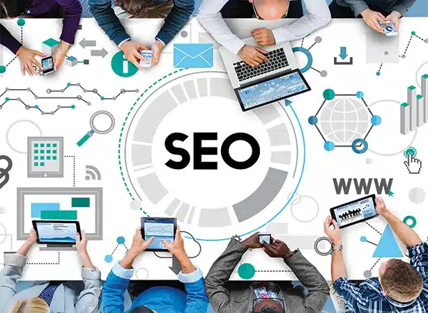 This image highlights the concept of SEO, surrounded by people using digital devices—symbolizing teamwork, connectivity, and strategy. A **digital marketing company in Kochi** can harness SEO to boost online visibility, drive traffic, and enhance brand presence. It reflects collaboration and the power of search optimization in the digital landscape.